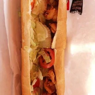 a chicken sandwich with lettuce and tomatoes