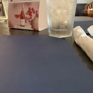 a glass of water and a napkin on a table