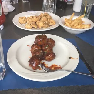 Meatball appetizer with fries and a breaded mushroom appetizer