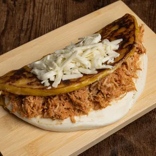  pulled pork sandwich on a wooden cutting board