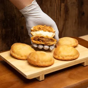  person holding a sandwich on a cutting board