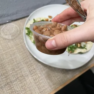 a person holding a spoon over a plate of food