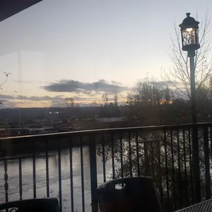 a table and chairs on a balcony overlooking a river