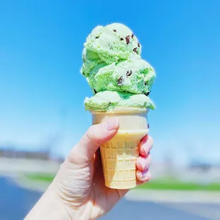 a hand holding an ice cream cone