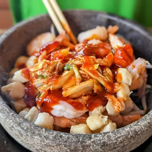 a bowl of food with chopsticks