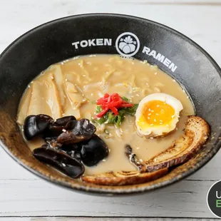 a bowl of ramen with a boiled egg and mussels