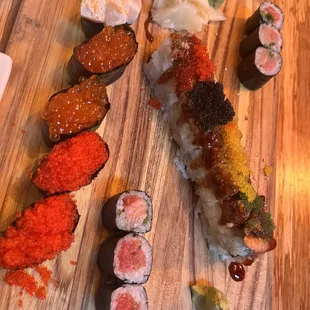 a variety of sushi on a wooden board