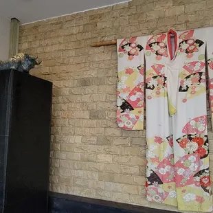 a kimono hanging on a brick wall