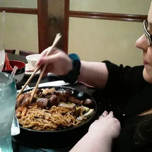 My wife eating hibachi steak with fried rice, noodles and mixed vegetables