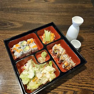 a bento box with sushi and vegetables