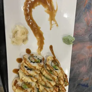 Amazing delicious sushi with a cool little dragon design on the plate