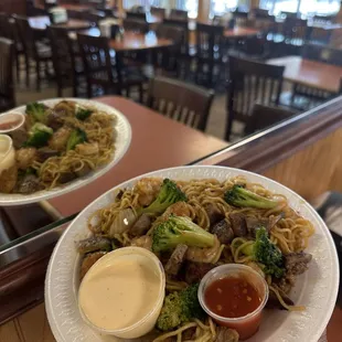 a plate of noodles with beef and broccoli