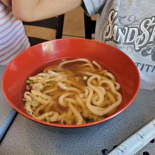 a bowl of noodles and chopsticks