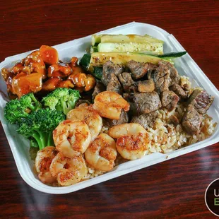 a plate of food with shrimp, broccoli, and rice