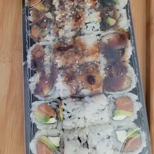 a tray of sushi and a glass of orange juice