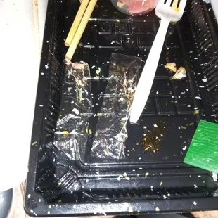 a plastic tray with food and chopsticks