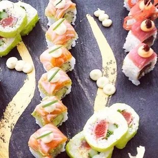 a variety of sushi on a slate board