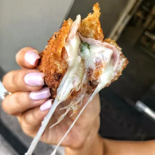 a hand holding a half eaten sandwich