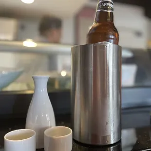 a bottle of beer and cups