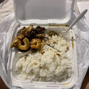 a take out box with rice and meat