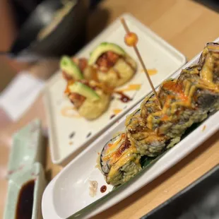 a plate of sushi and a plate of avocado