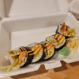 a sushi roll in a styrofoam container