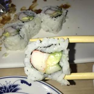 a plate of sushi and chopsticks