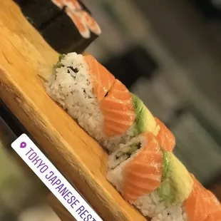 a sushi roll with salmon and avocado
