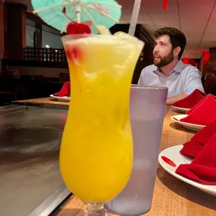 a man sitting at a table with a drink
