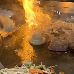 a man cooking steaks on a grill