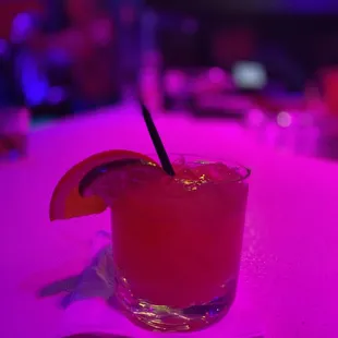 a cocktail with a slice of grape