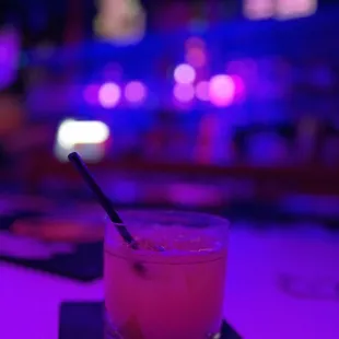 a pink cocktail with a black straw