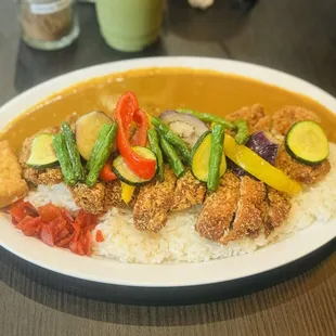 Chicken katsu curry with a side of veggies and fried tofu