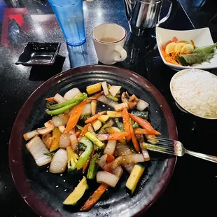 a plate of vegetables and rice on a table