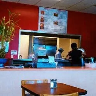 a restaurant counter with a man in the background