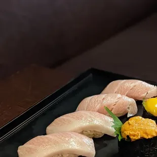 a variety of sushi on a black plate