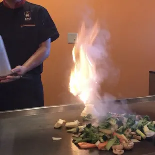 The chef cooking onions in the shape of a volcano