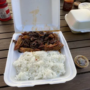 a take out box with rice and meat