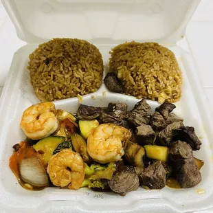 a styrofoam takeout box with a variety of food items