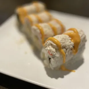 a plate of sushi with sauce on it
