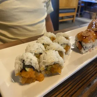 a plate of sushi and rolls