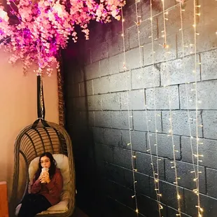 a woman sitting in a hanging chair