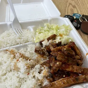 a plate of rice, meat, and coleslaw