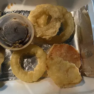 onion rings and dipping sauce in a styrofoam container