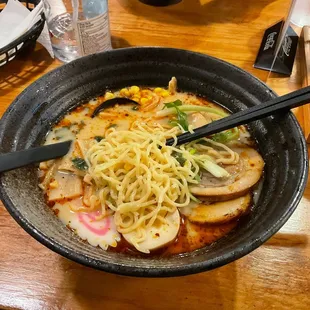 a bowl of ramen noodles with chopsticks