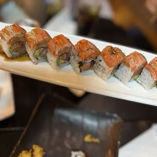 a person holding a plate of sushi