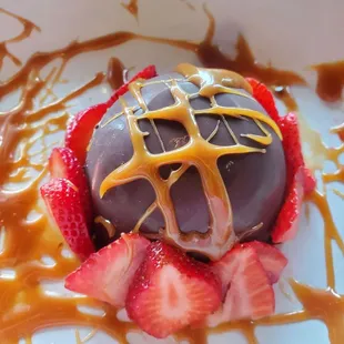 a chocolate covered strawberry with caramel drizzle