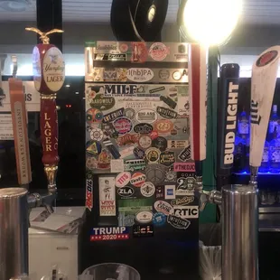 a beer tap with a bunch of stickers on it