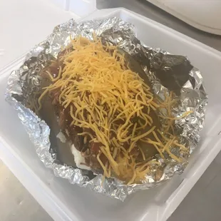 a hot dog covered in cheese