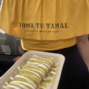 Chicken tamale topped with sour cream and green salsa